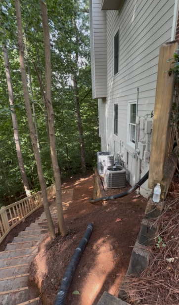 Cleared side yard with drain line run after brush and growth were cut out