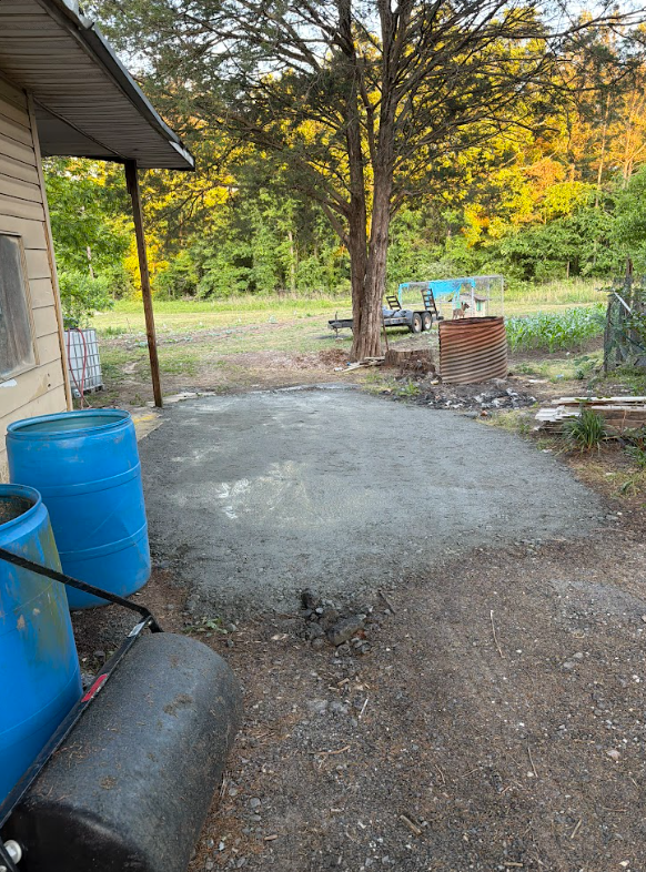 Gravel parking pad graded smooth beside a house at the end of a driveway