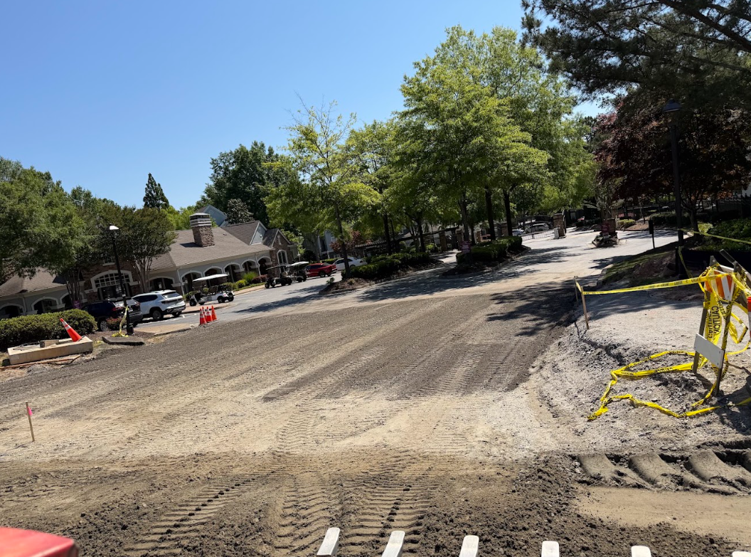 Wide driveway and drive lane freshly graded and compacted with tire tracks through a neighborhood entrance