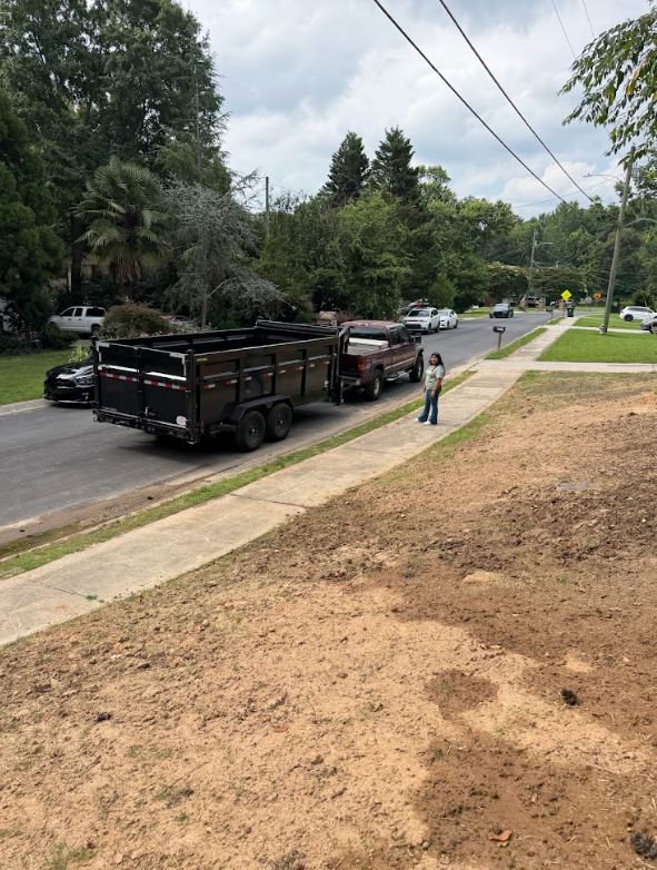 Truck and dump trailer staged at the curb during a yard cleanup and haul-off job